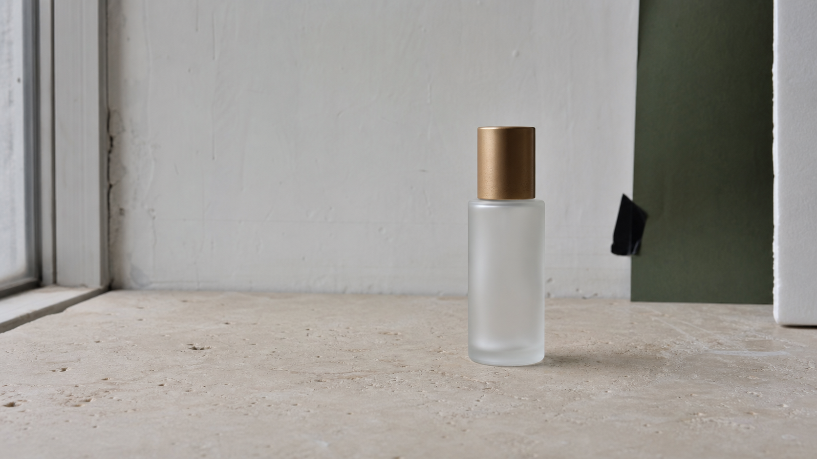 Before — unretouched source photograph of a frosted serum bottle on a limestone sill beside a real window.